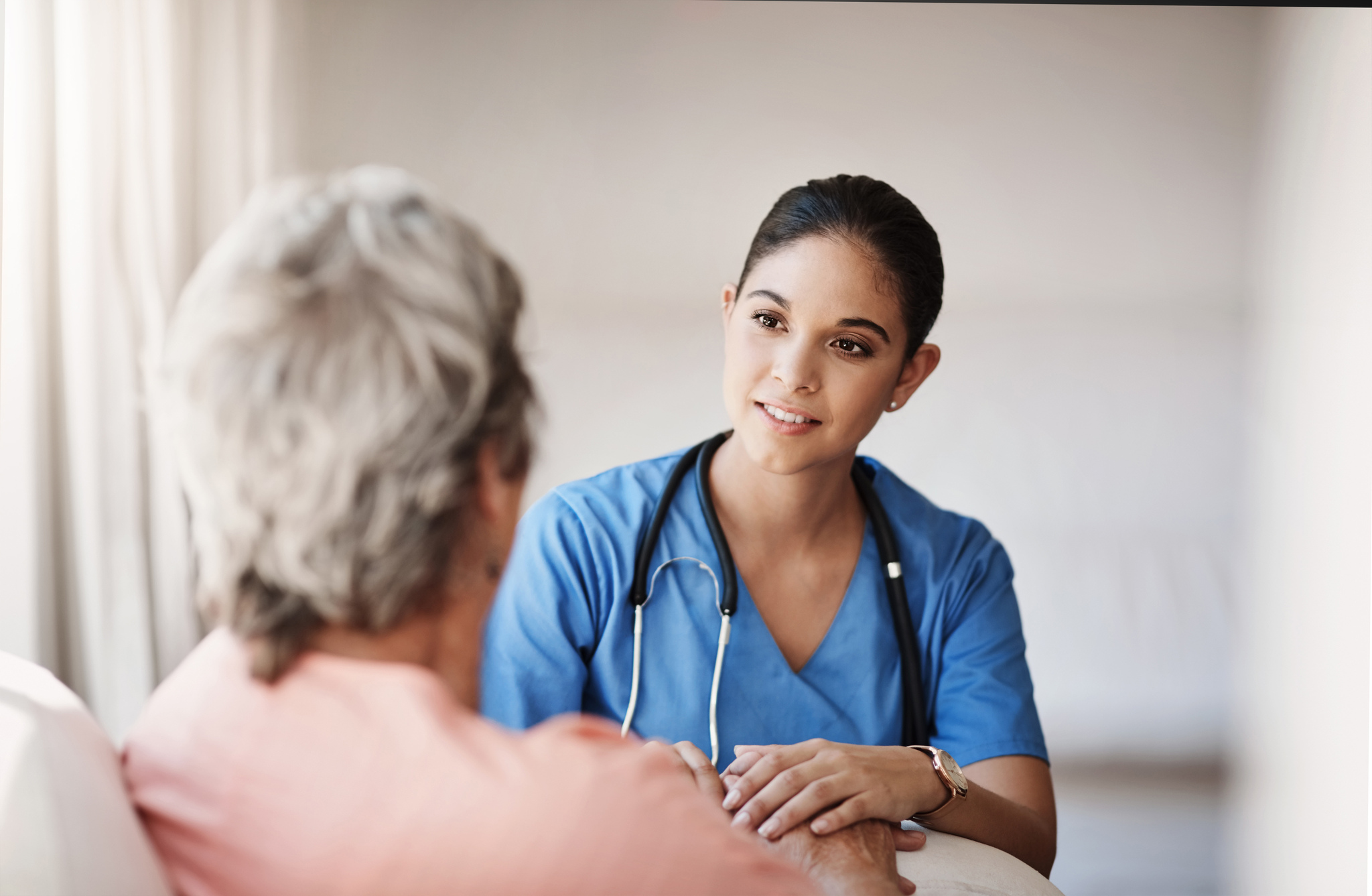 female nurse talking to an elderly patient